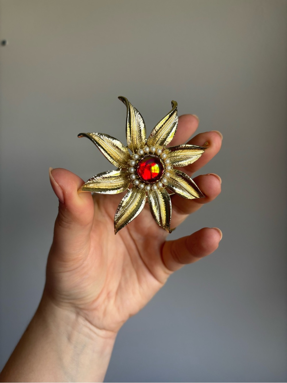 Vintage 1960s brooch gold tone flower with a ruby/garnet centre stone